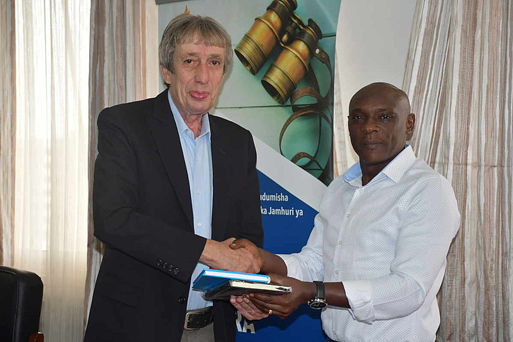 The Chief of Police Force in Tanzania Mr. Camillus Mongoso Wambura receiving HSF notebooks from Mr. Karl-Peter Schönfisch, HSF Resident Representative for Tanzania and Uganda.   