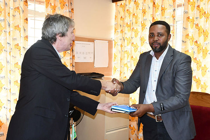 Mr. Karl-Peter Schönfisch, Hanns Seidel Foundation Resident Representative for Tanzania and Uganda handing over the publicity material to Dr. Masinda National College of Tourism-Manager in Arusha  